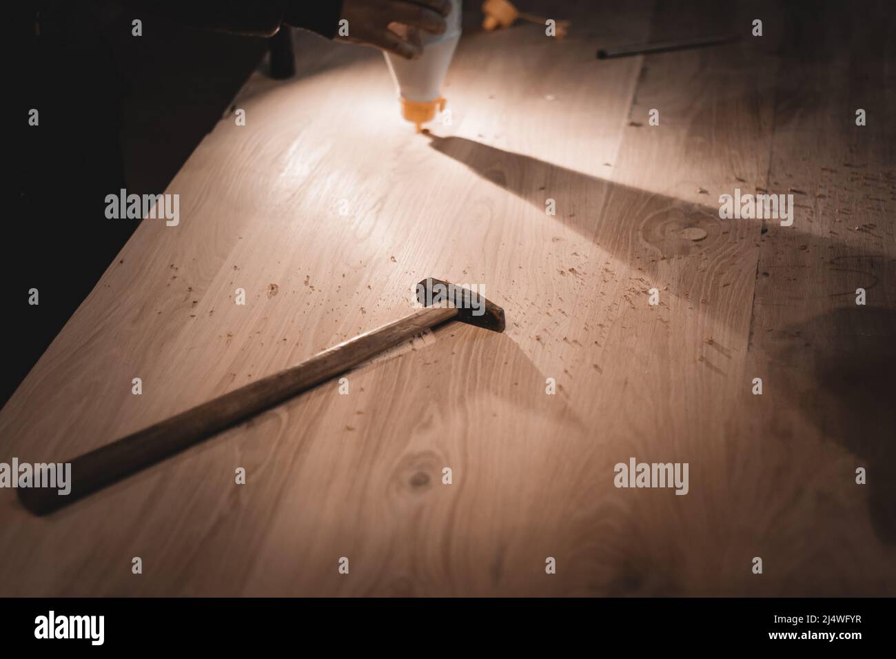 Un ancien marteau avec une longue poignée. Petits outils de travail d'un charpentier sur une table poussiéreuse. Banque D'Images