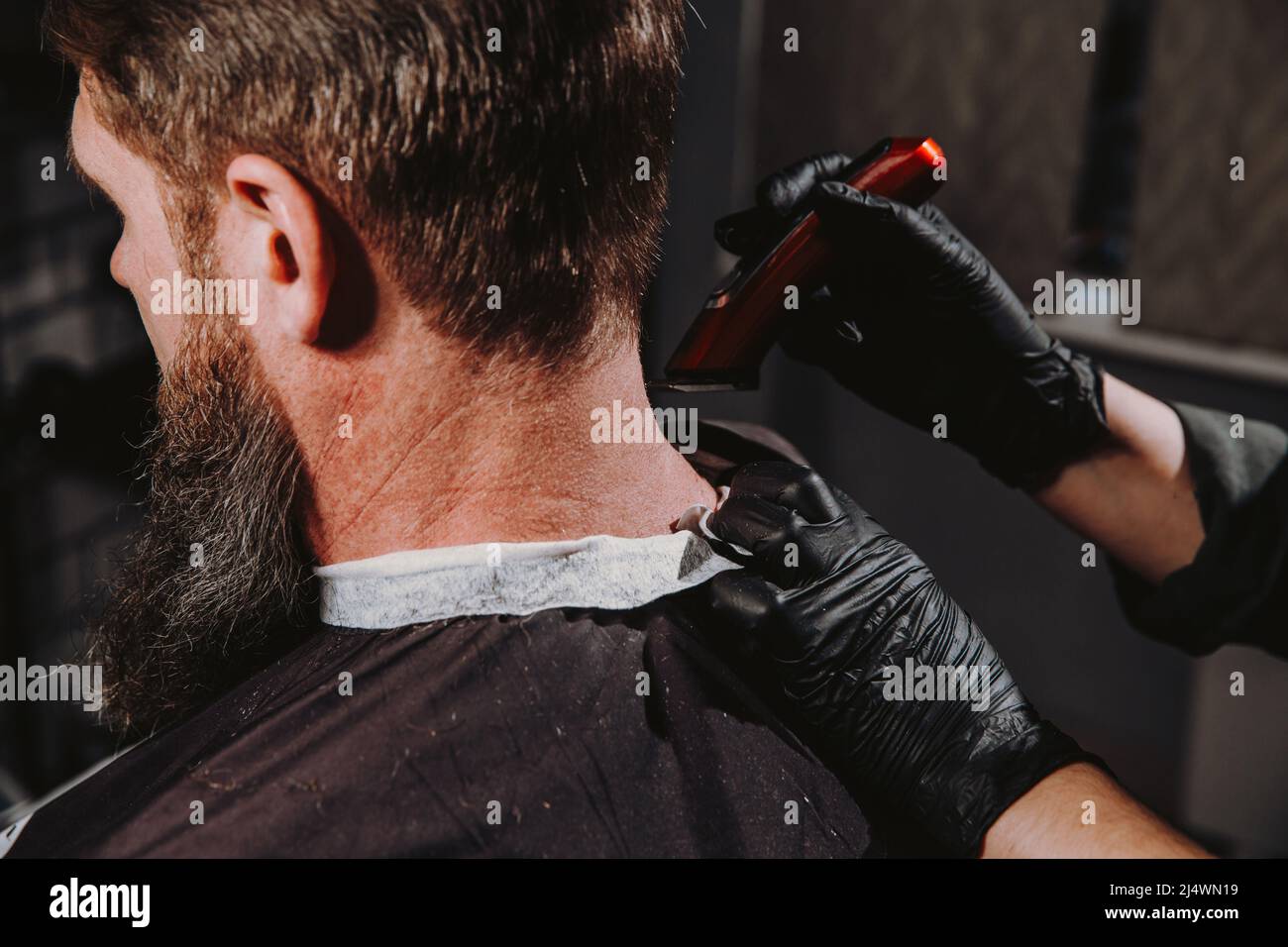 Homme qui obtient une coupe de cheveux tendance au salon de coiffure. Banque D'Images