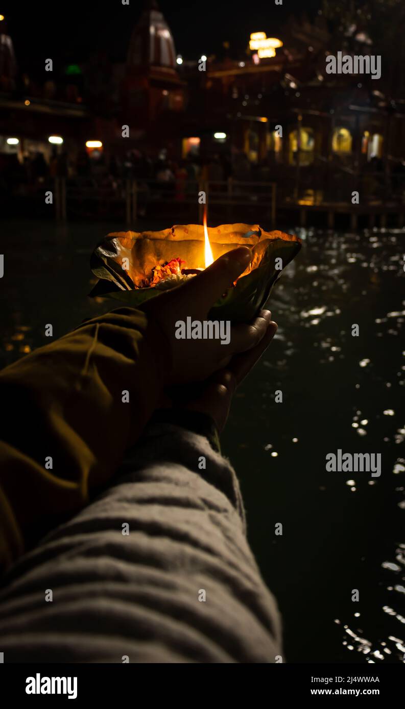 défotee tenant aarti pot de fleurs pour la prière du soir de la rivière ganges la nuit Banque D'Images