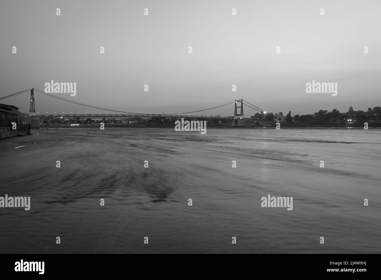 pont en suspension de fer avec coucher de soleil ciel spectaculaire et eau de rivière fluide floue au matin image est prise à rishikesh uttrakhand inde. Banque D'Images pont en suspension de fer avec coucher de soleil ciel spectaculaire et eau de rivière fluide floue au matin image est prise à rishikesh uttrakhand inde. Banque D'Images