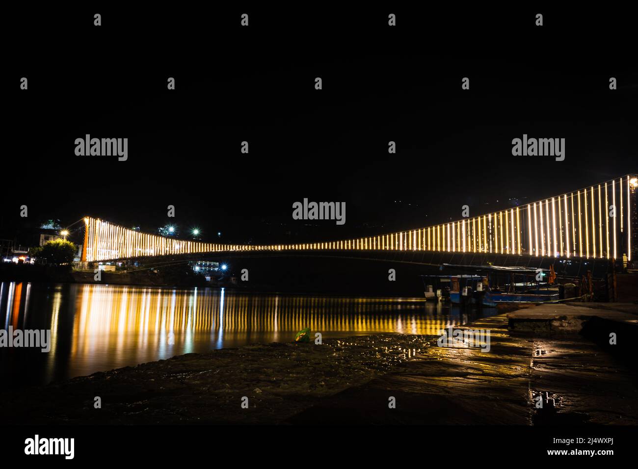 pont de suspension de fer éclairé avec des lumières de ferry avec réflexion d'eau de différents angles image est prise à rishikesh uttrakhet inde. Banque D'Images