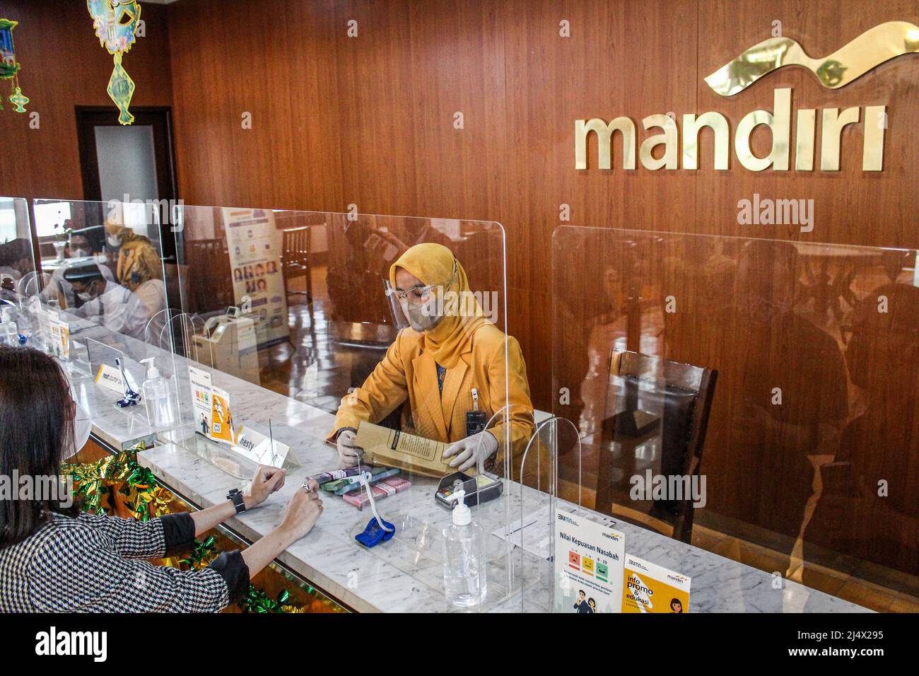 Bandung, Indonésie. 18th avril 2022. Une femme arrange des paquets de billets de roupie indonésiens à l'unité Mandiri Mikro Bandung Alun-Alun à Bandung. Bank Mandiri Region VI/Java 1 prépare des besoins en espèces d'environ 6,6 000 milliards d'IDR pour anticiper l'augmentation des besoins en espèces des habitants de Java Ouest. La valeur comprend 6,1 000 IDR pour la facturation de 1207 DAB et 535 milliards de RP pour les besoins des clients au cours des 33 prochains jours, du 7 avril au 9 mai 2022, pendant la période du Ramadan et avant Eid al-Fitr 1443 H. crédit: SOPA Images Limited/Alay Live News Banque D'Images