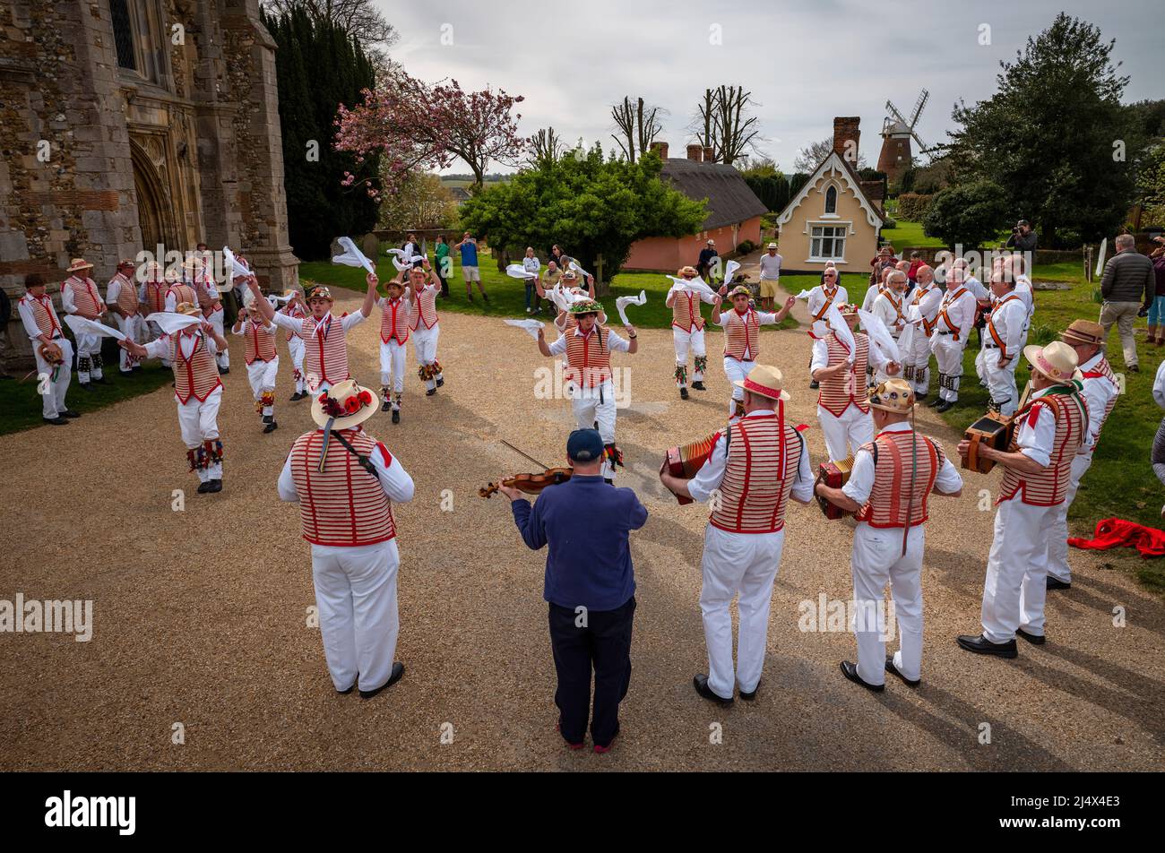 Lundi de Pâques Morris Dancing Thaxted Essex, Royaume-Uni. 18th avril 2022. À la fin du printemps, par temps chaud, les danseuses de Morris Thaxted en rouge et blanc, en visitant les danseurs de Dyke Morris en marron et en blanc du sud du Cambridgshire, effectuent des danses traditionnelles de dMorris dans le triage de l'église de Thaxted avec les maisons d'alms Thaxted et le moulin de John Webb en arrière-plan. Crédit : BRIAN HARRIS/Alay Live News Banque D'Images