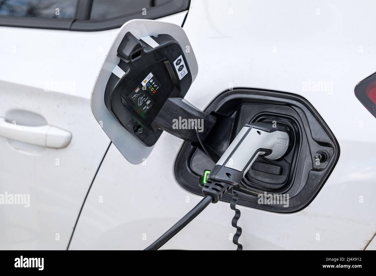 Gros plan de la fixation de câble électrique pour voiture électrique en cours de charge au point de charge de voiture, Royaume-Uni Banque D'Images