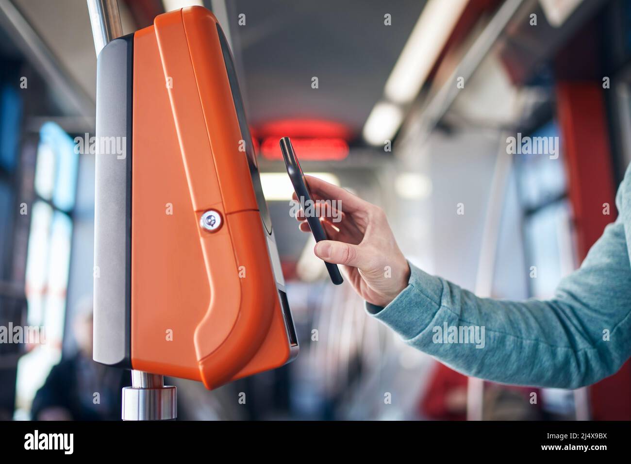 Homme achetant un billet via un portefeuille numérique. Paiement sans contact pour les transports en commun avec téléphone mobile. Banque D'Images