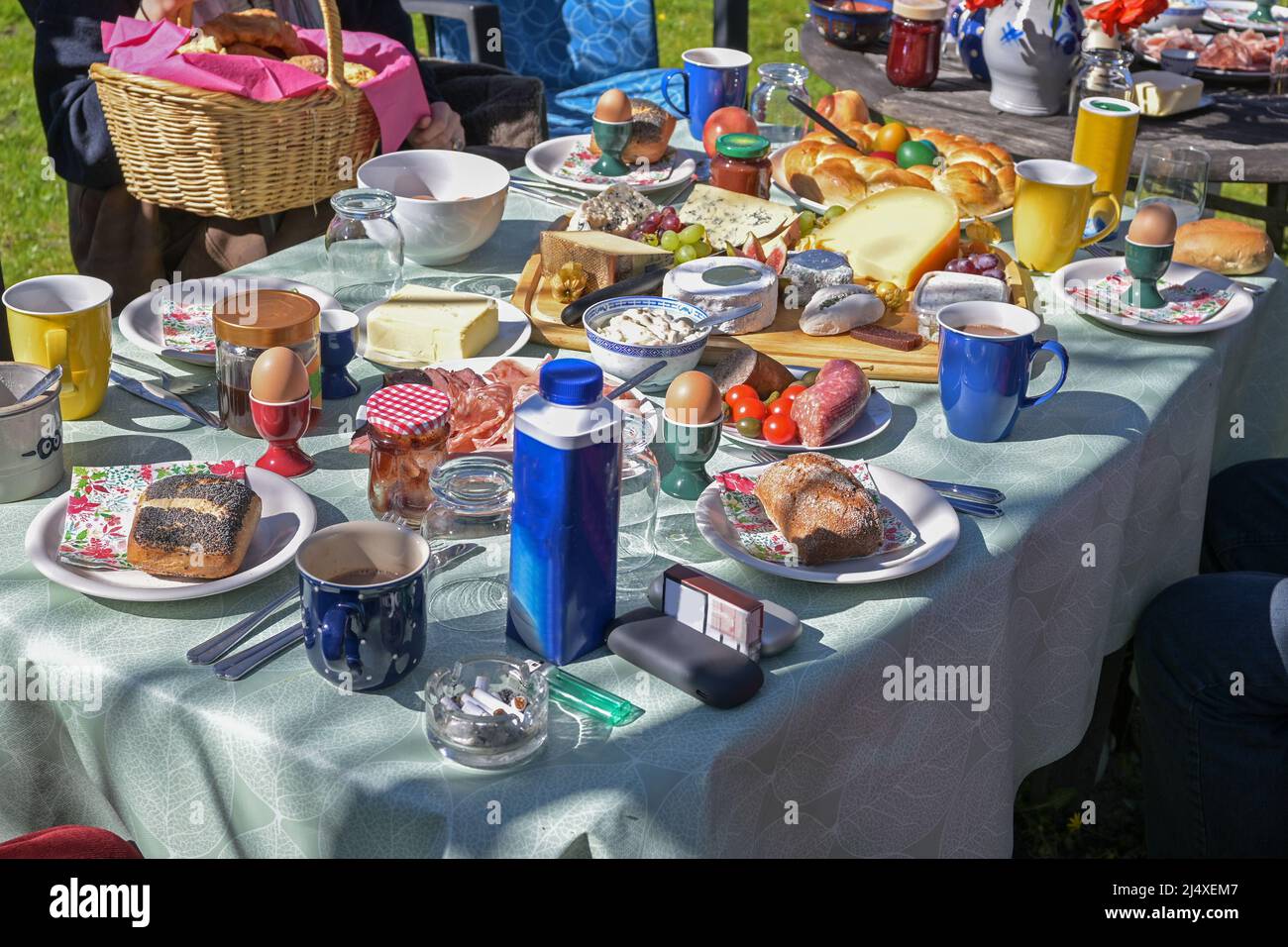 Grande table à un brunch de Pâques décontracté en plein air avec la famille et beaucoup de clients plein de nourriture dans le jardin, par une journée ensoleillée, sélection de foyer, profondeur étroite Banque D'Images