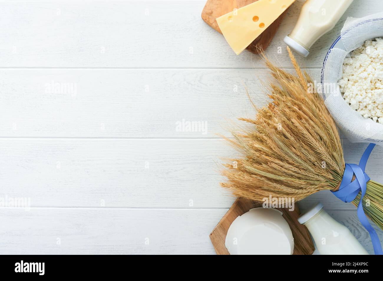 Fête juive de Shavuot. Lait et fromage, blé mûr et fruits, crème sur fond de bois blanc. Produits laitiers sur fond de bois blanc Banque D'Images