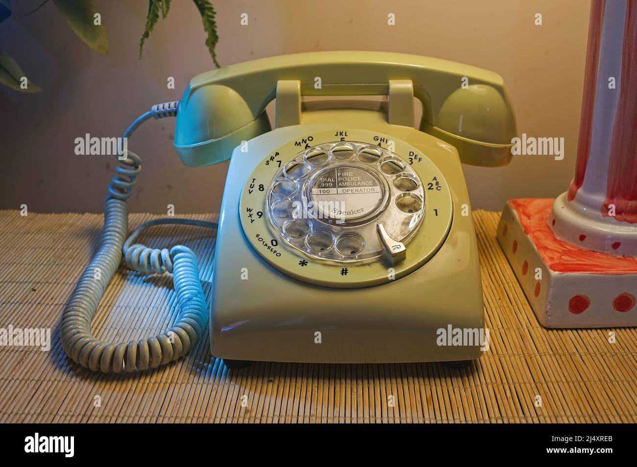 Téléphone à cadran rotatif de style rétro éclairé par une lampe dans la maison Banque D'Images