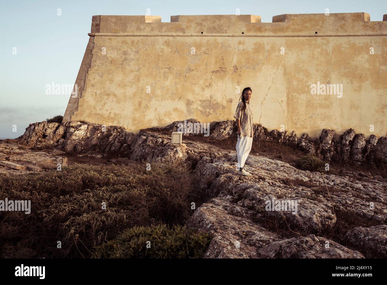 Personne androgyne se tient devant le fort historique au Portugal Banque D'Images