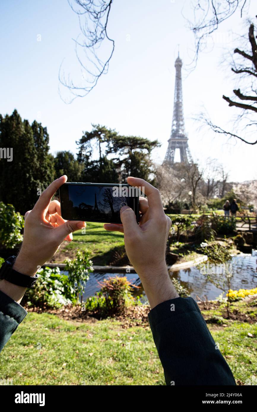 Homme prenant des photos de la Tour Eiffel à l'aide d'un smartphone Banque D'Images