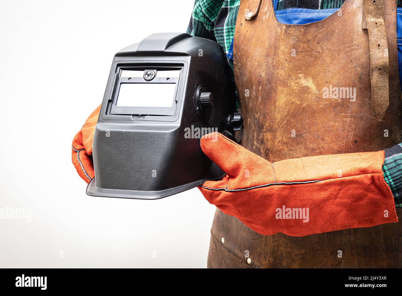 Travailleur de l'industrie lourde dans une combinaison de protection, gants, tenant un masque de protection sous son bras, gros plan, fond blanc Banque D'Images