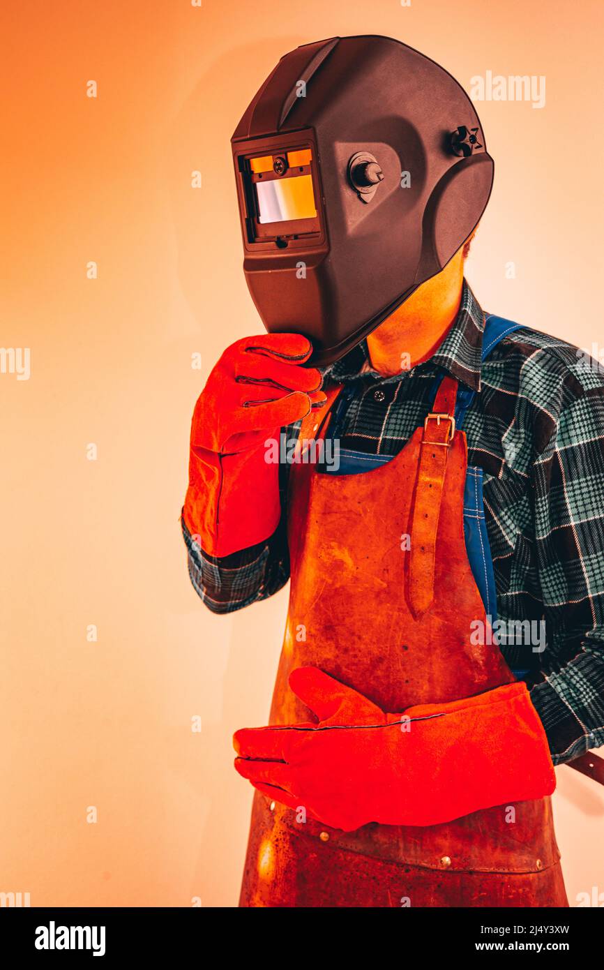 Travailleur de l'industrie lourde en combinaison de protection avec masque pour protéger les yeux et le visage, photo verticale, gros plan, couleurs vives Banque D'Images