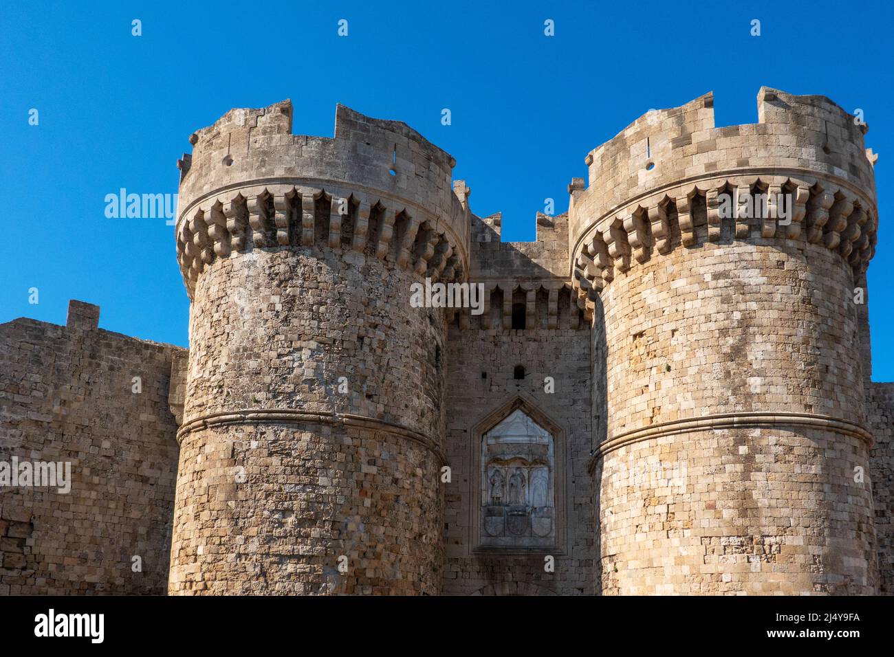 Rhodes, Grèce - 28 septembre 2021. Porte de la mer. Chemin d'entrée en pierre du Moyen-âge, avec des tours crénelées doubles et des reliefs chrétiens. Banque D'Images