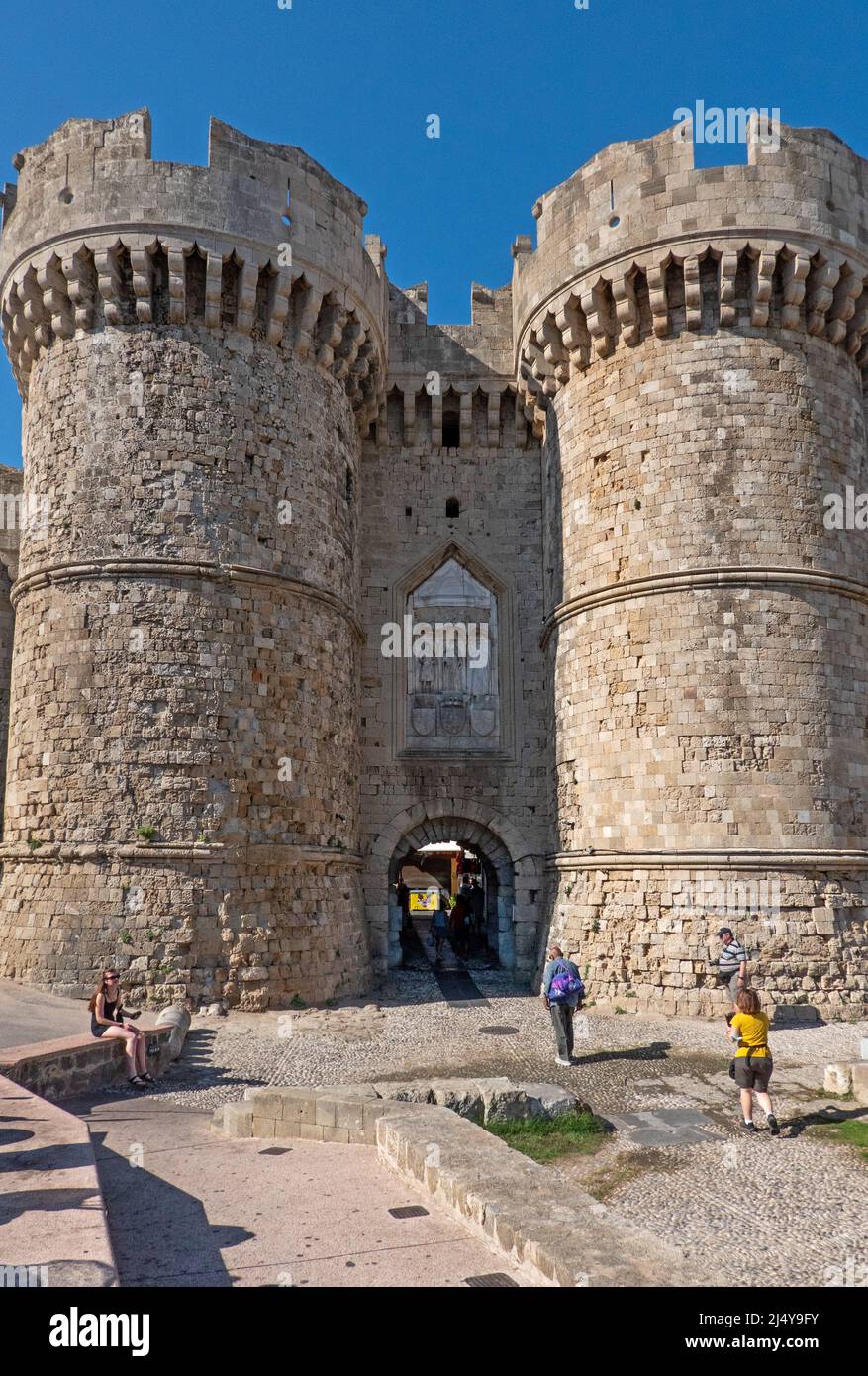 Rhodes, Grèce - 28 septembre 2021. Porte de la mer. Chemin d'entrée en pierre du Moyen-âge, avec des tours crénelées doubles et des reliefs chrétiens. Banque D'Images