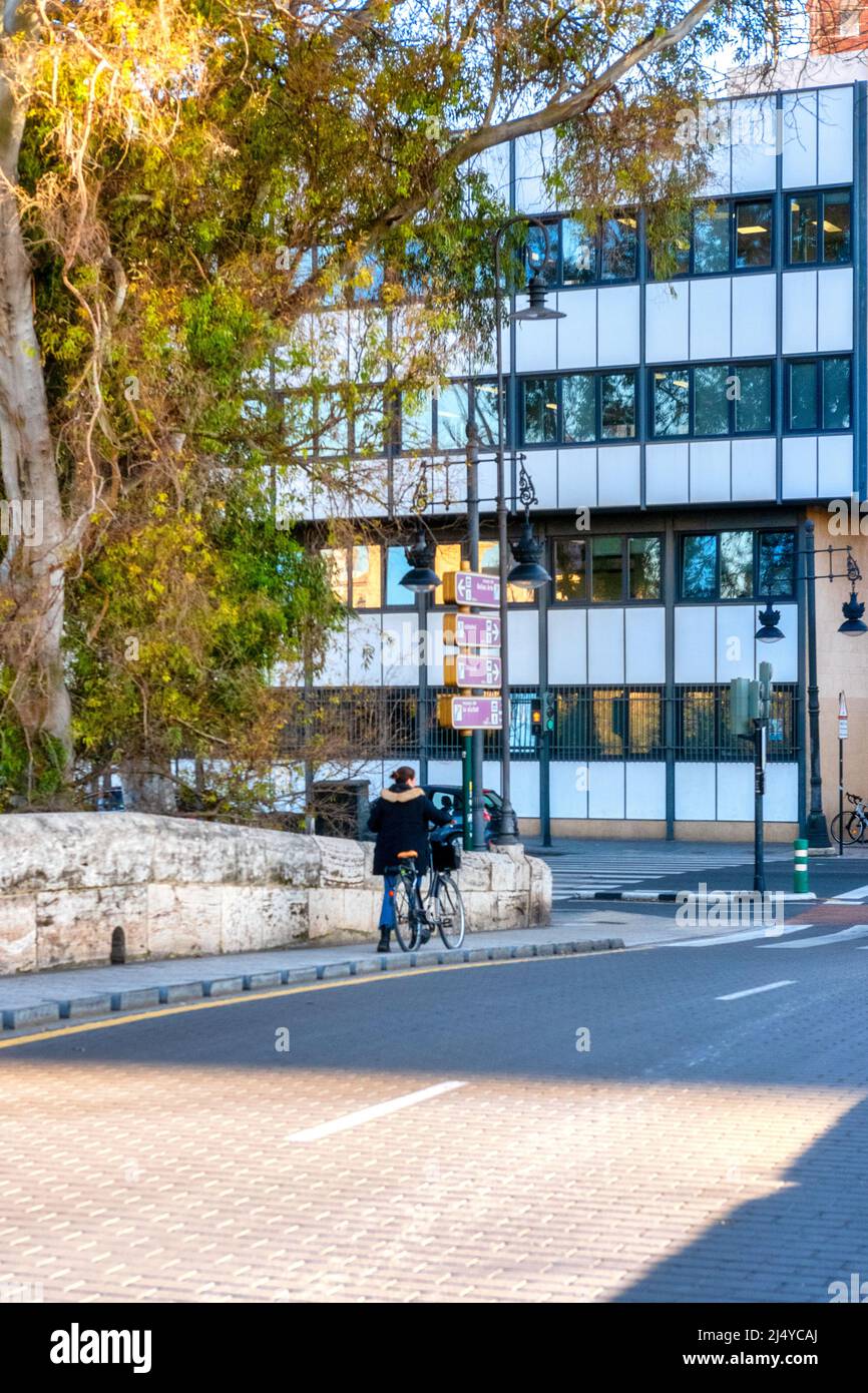 Une femme pousse un vélo dans un vieux pont avec une rue pavée. La vieille ville est une attraction touristique majeure. La ville de Valence est la capitale du S Banque D'Images