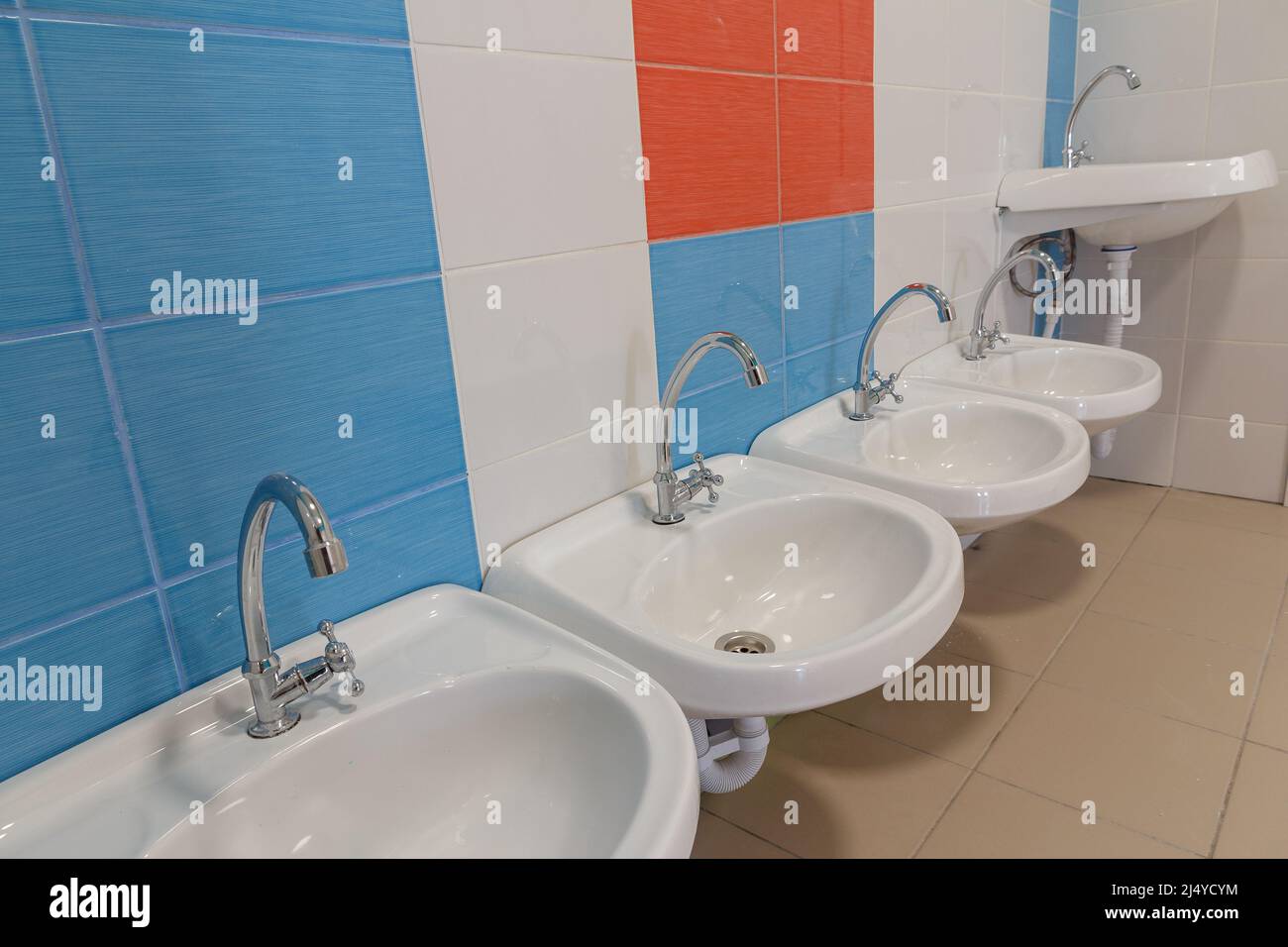 Toilettes dans la maternelle. Petits éviers pour se laver les mains dans les toilettes de la maternelle. Banque D'Images