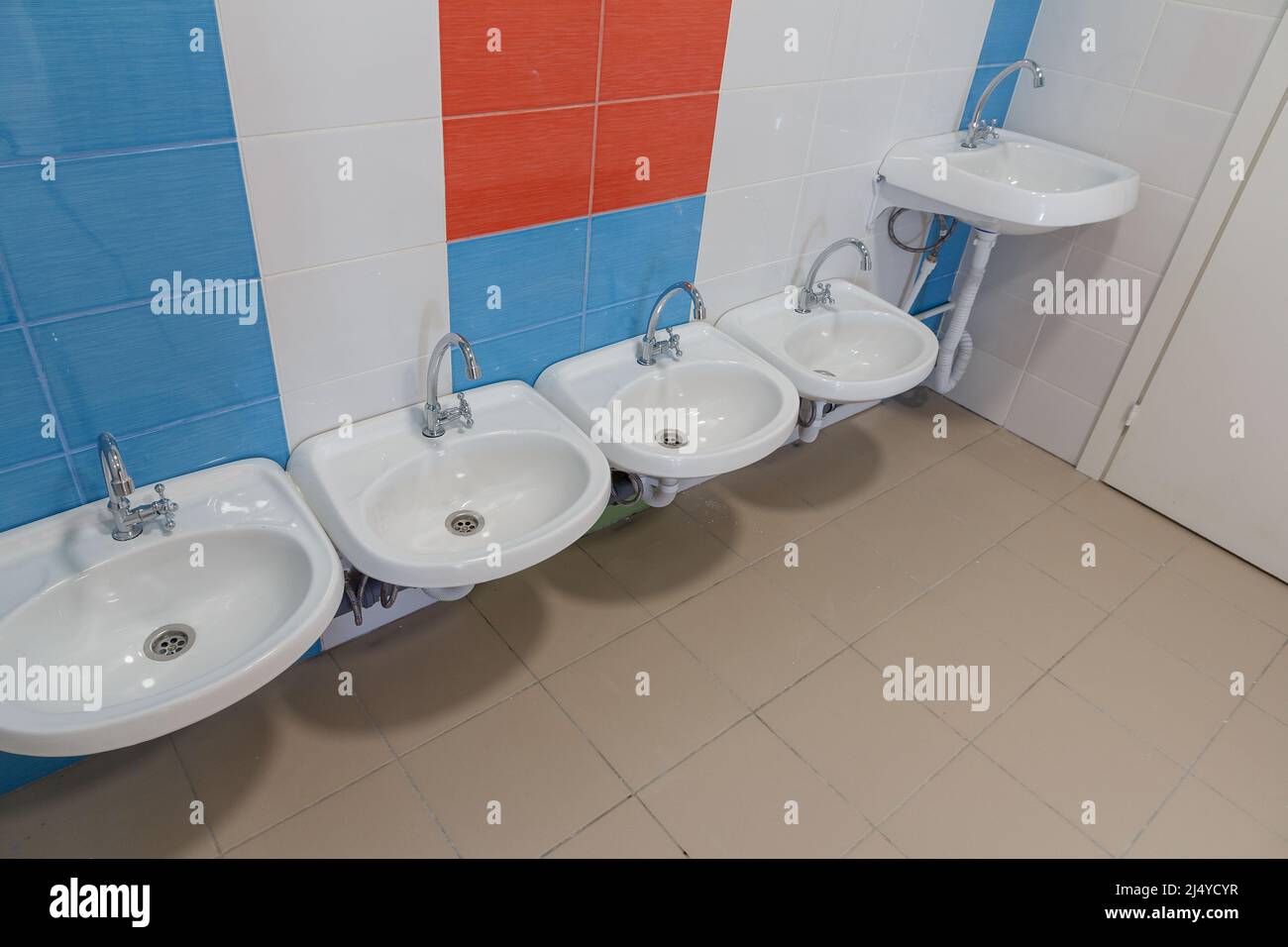 Toilettes dans la maternelle. Petits éviers pour se laver les mains dans les toilettes de la maternelle. Banque D'Images
