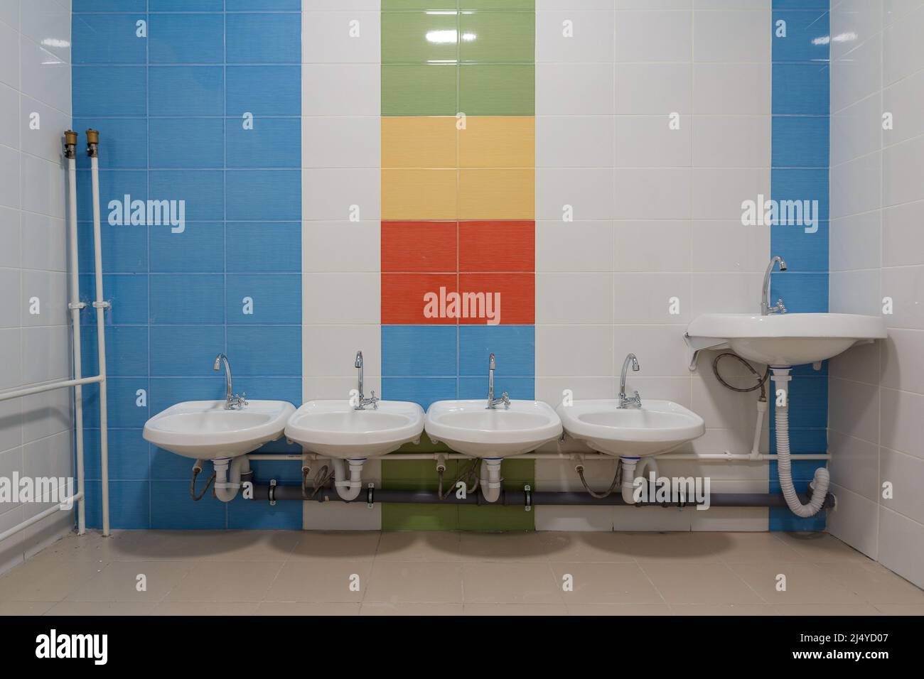 Toilettes dans la maternelle. Petits éviers pour se laver les mains dans les toilettes de la maternelle. Banque D'Images