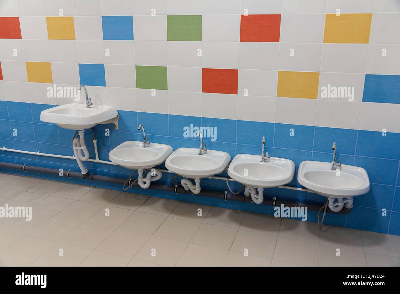 Toilettes dans la maternelle. Petits éviers pour se laver les mains dans les toilettes de la maternelle. Banque D'Images