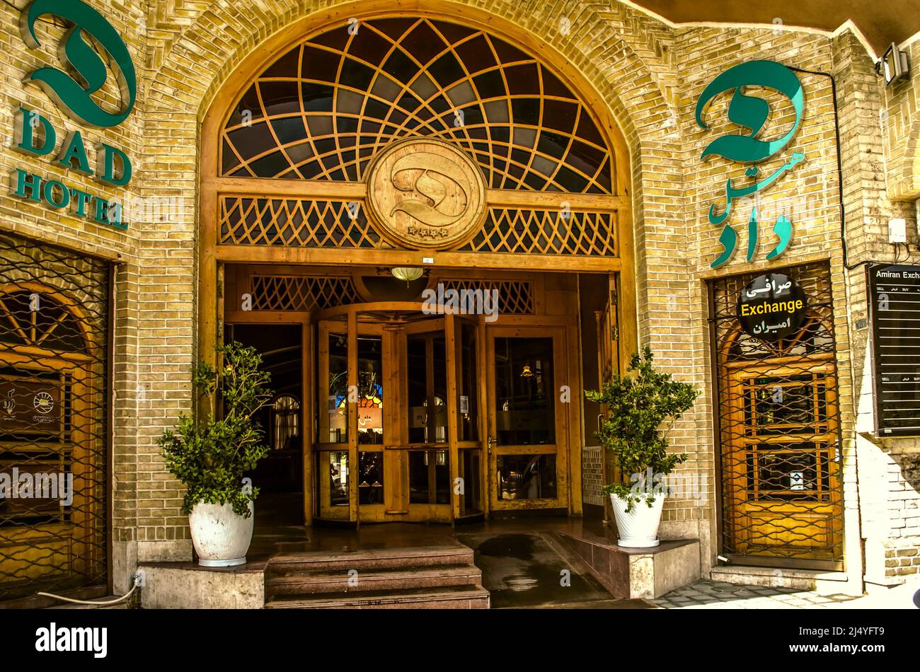 Yazd,Iran,février 19,2021: Entrée tournant porte en bois avec une fenêtre ovale en vitrail sur le dessus, encadrée par un bord de brique sur la façade de la DAD Ho Banque D'Images