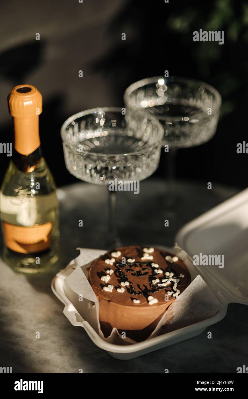 Gâteau à bento au chocolat avec un peu de champagne pour une petite fête d'anniversaire. Des verres à champagne exquis sur une table en marbre de luxe. Gâteau pour deux personnes Banque D'Images
