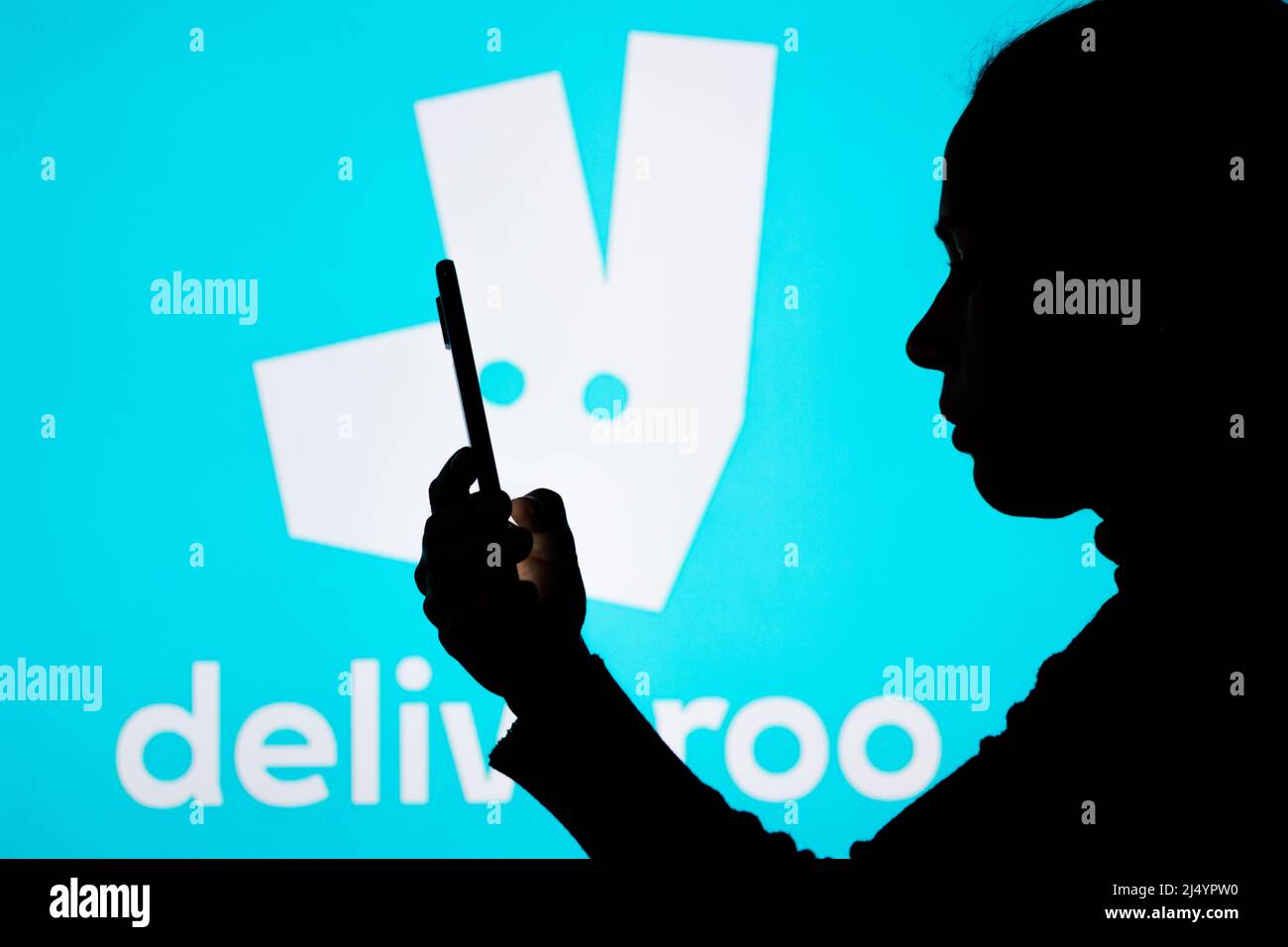Dans cette illustration, le logo Deliveroo vu en arrièreplan d'une