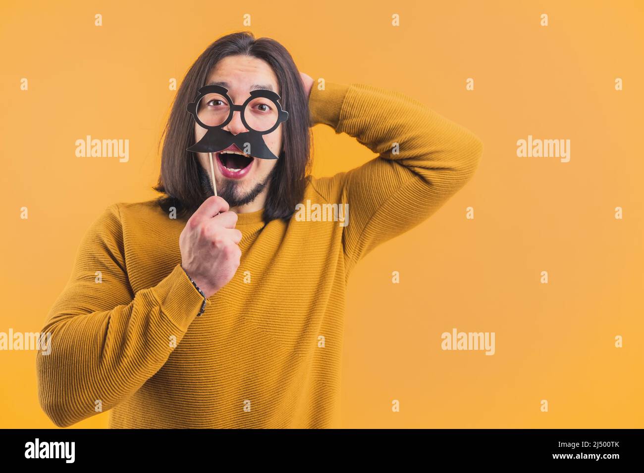 Movember - jeune homme caucasien tenant des verres en papier et la moustache sur le bâton jaune fond copie espace isolé studio tourné . Photo de haute qualité Banque D'Images