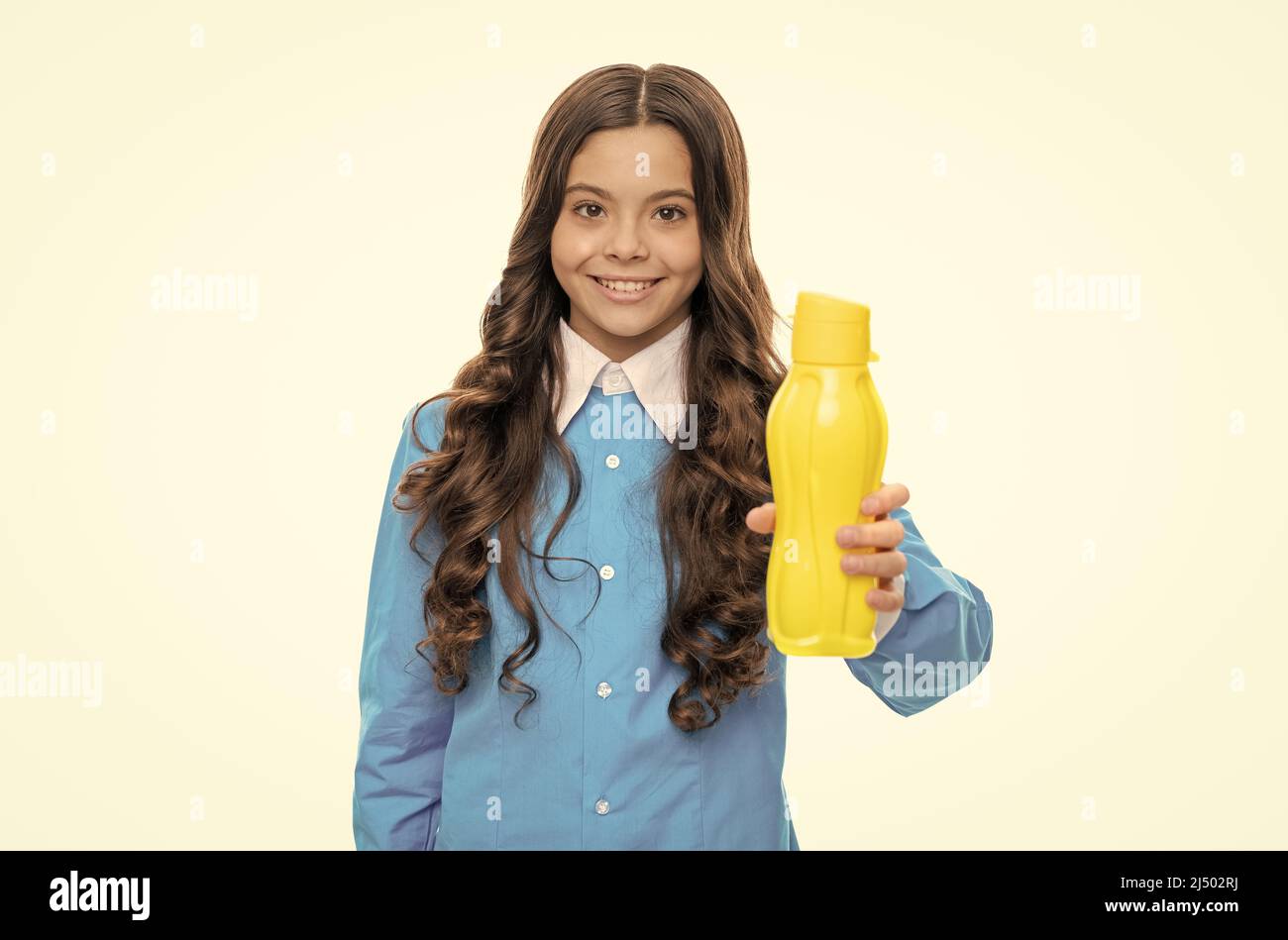 Happy Kid donner une bouteille en plastique jaune avec produit de boisson isolé sur blanc, buvable Banque D'Images