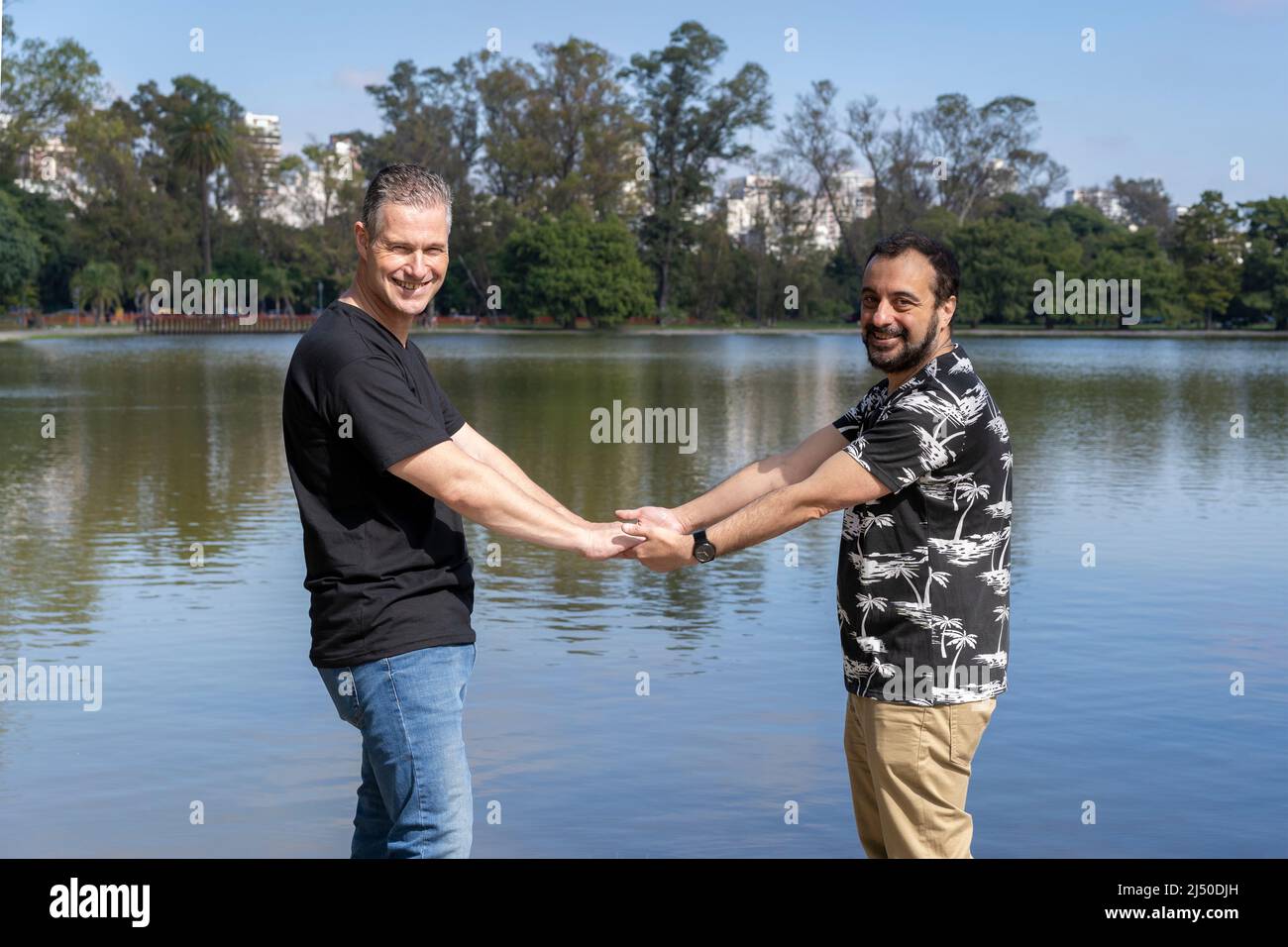 Homosexuel mature couple blanc mâle tenant les mains dos à dos à un lac Banque D'Images