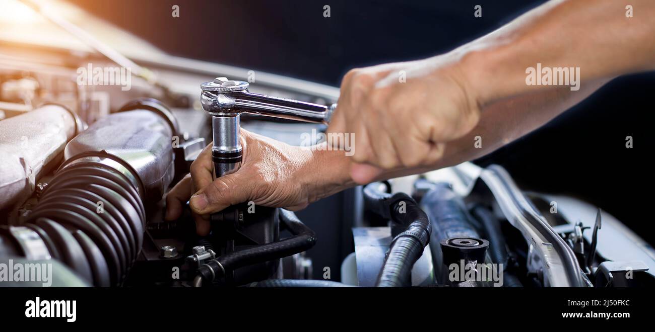 Mécanicien de voiture travaillant sur le moteur de voiture, concept d'entretien de voiture. Banque D'Images