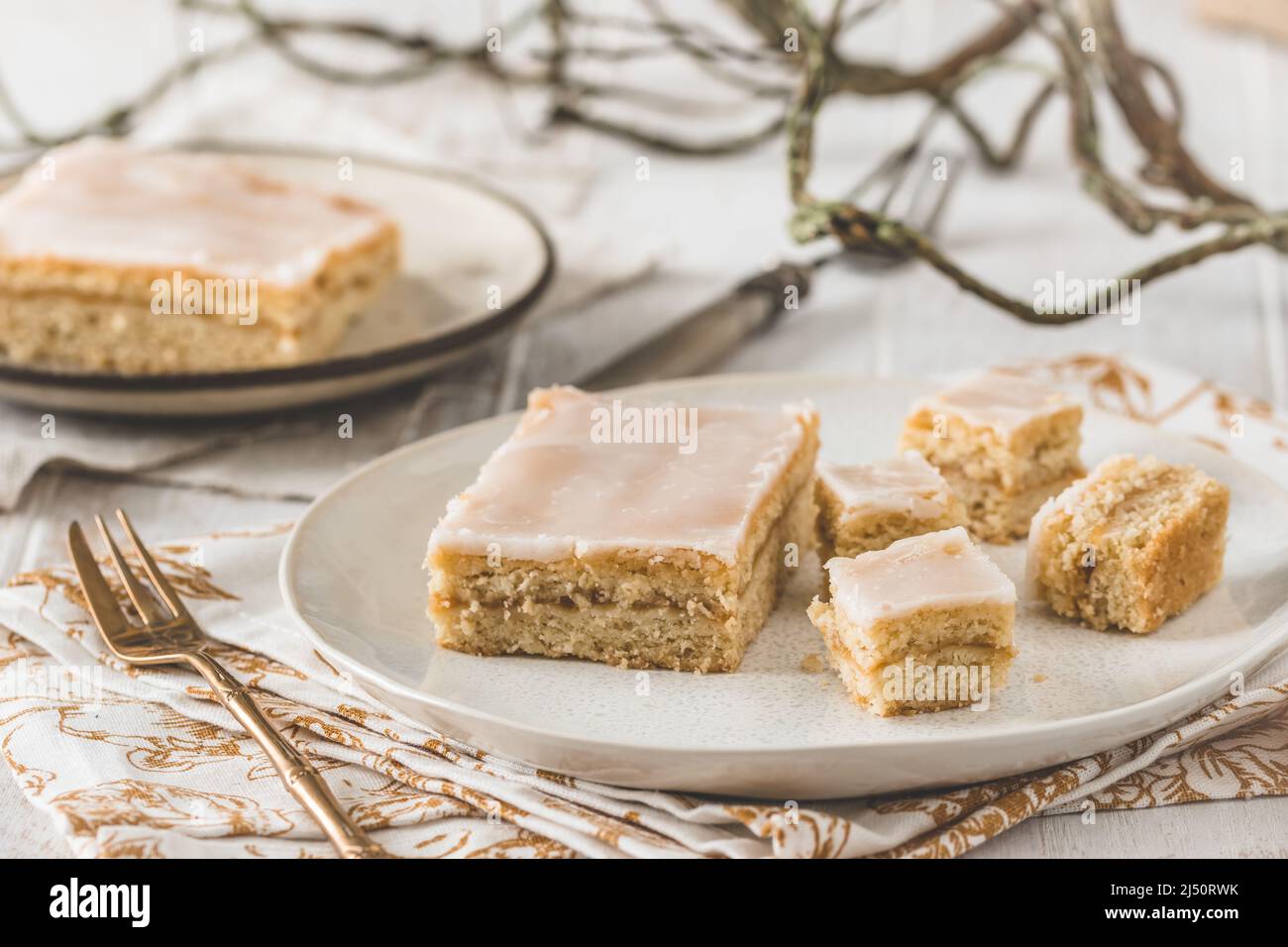 Morceaux de tarte aux pommes couverte avec glaçage au sucre sur fond de bois blanc. Concept de couleur harmonieuse dans les tons beige. Banque D'Images