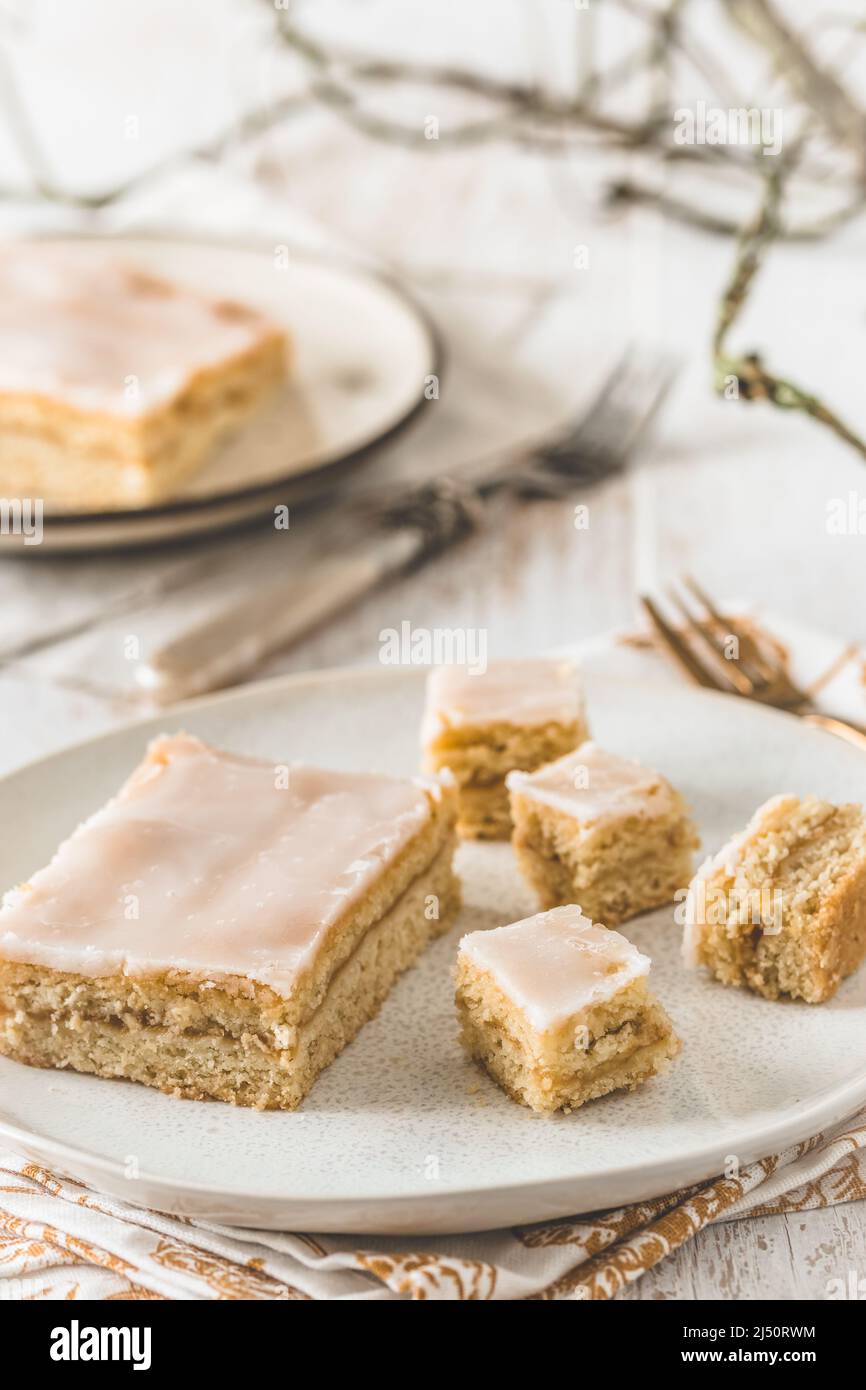 Morceaux de tarte aux pommes couverte avec glaçage au sucre sur fond de bois blanc. Concept de couleur harmonieuse dans les tons beige. Verticale. Banque D'Images