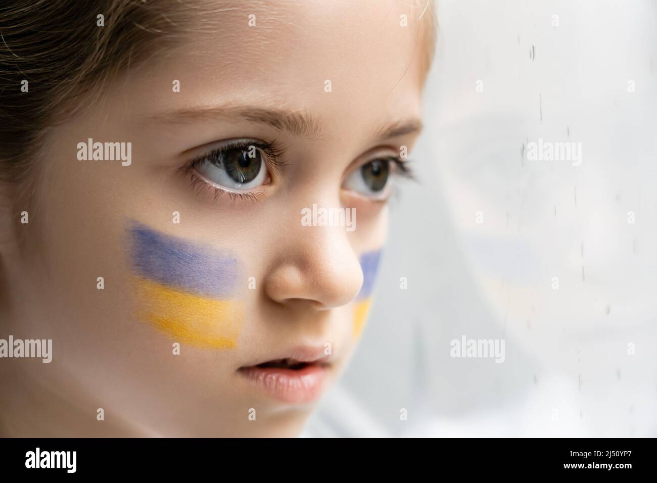 portrait en gros plan d'un enfant ukrainien avec drapeaux nationaux sur fond blanc Banque D'Images
