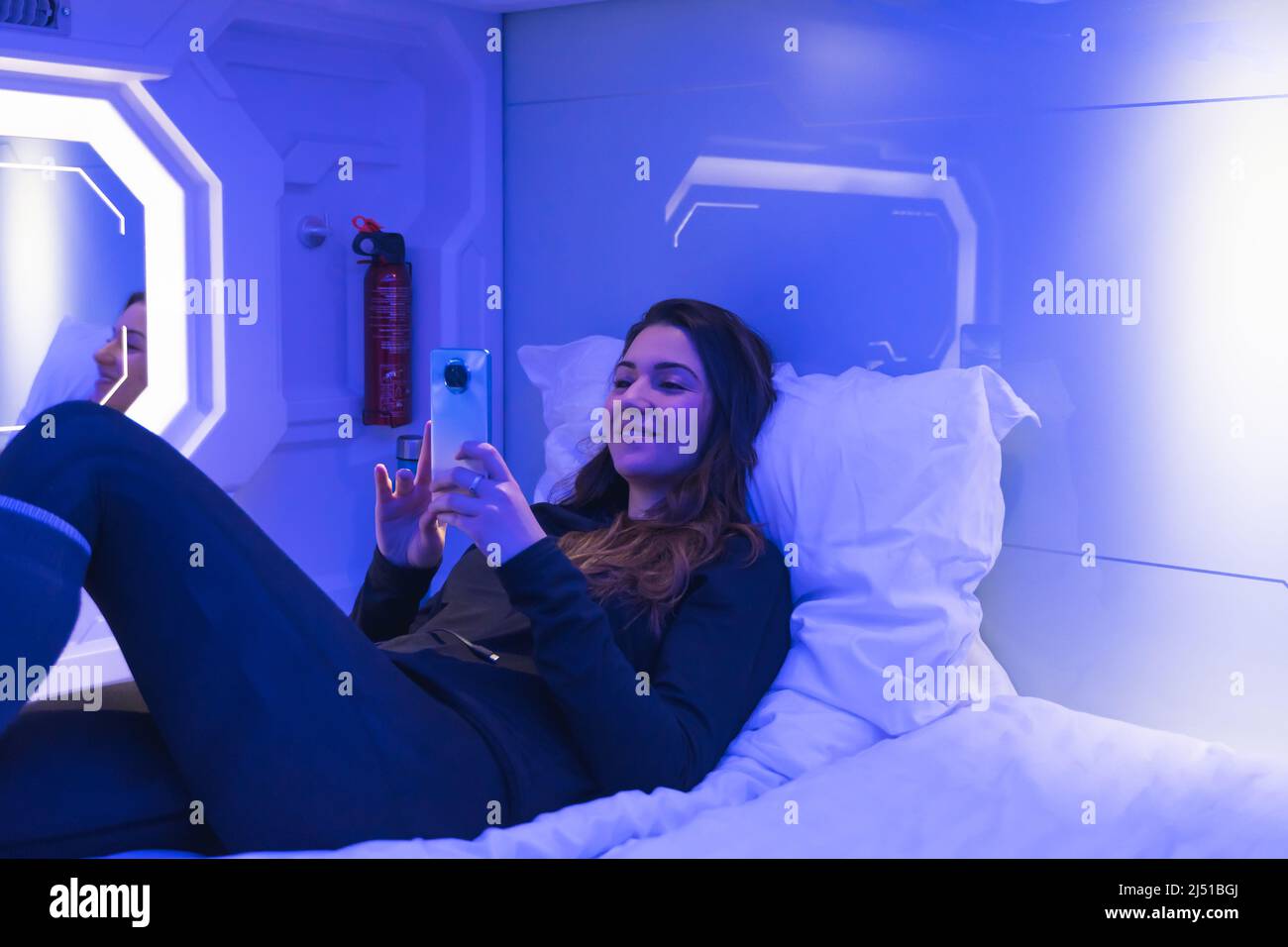 femme en capsule la nuit avec le téléphone Banque D'Images