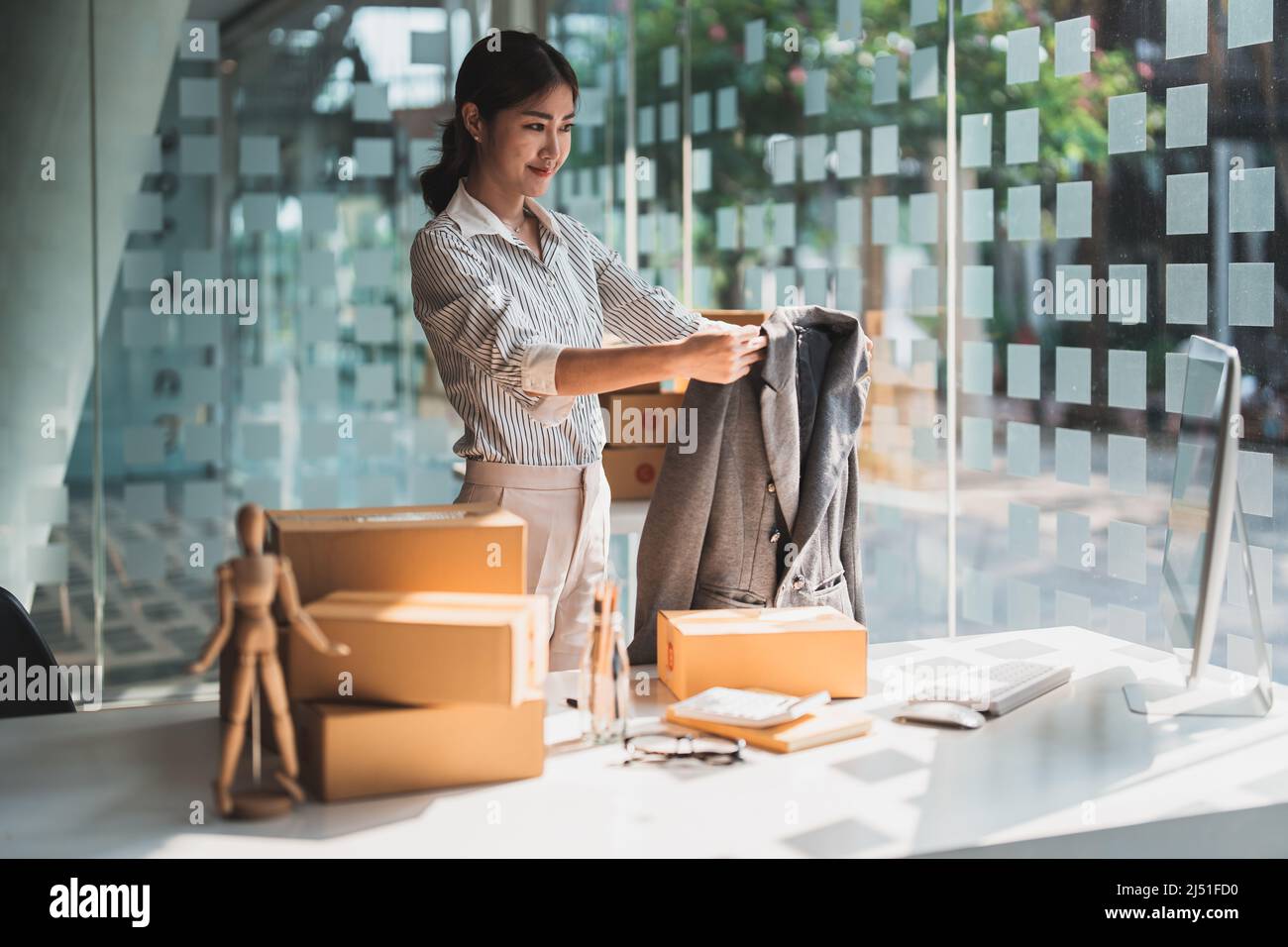 Jeune femme de mode asiatique utilisant l'ordinateur recevant le bon de commande et montrant des vêtements enregistrement vidéo en direct streaming à la maison. Petit Banque D'Images