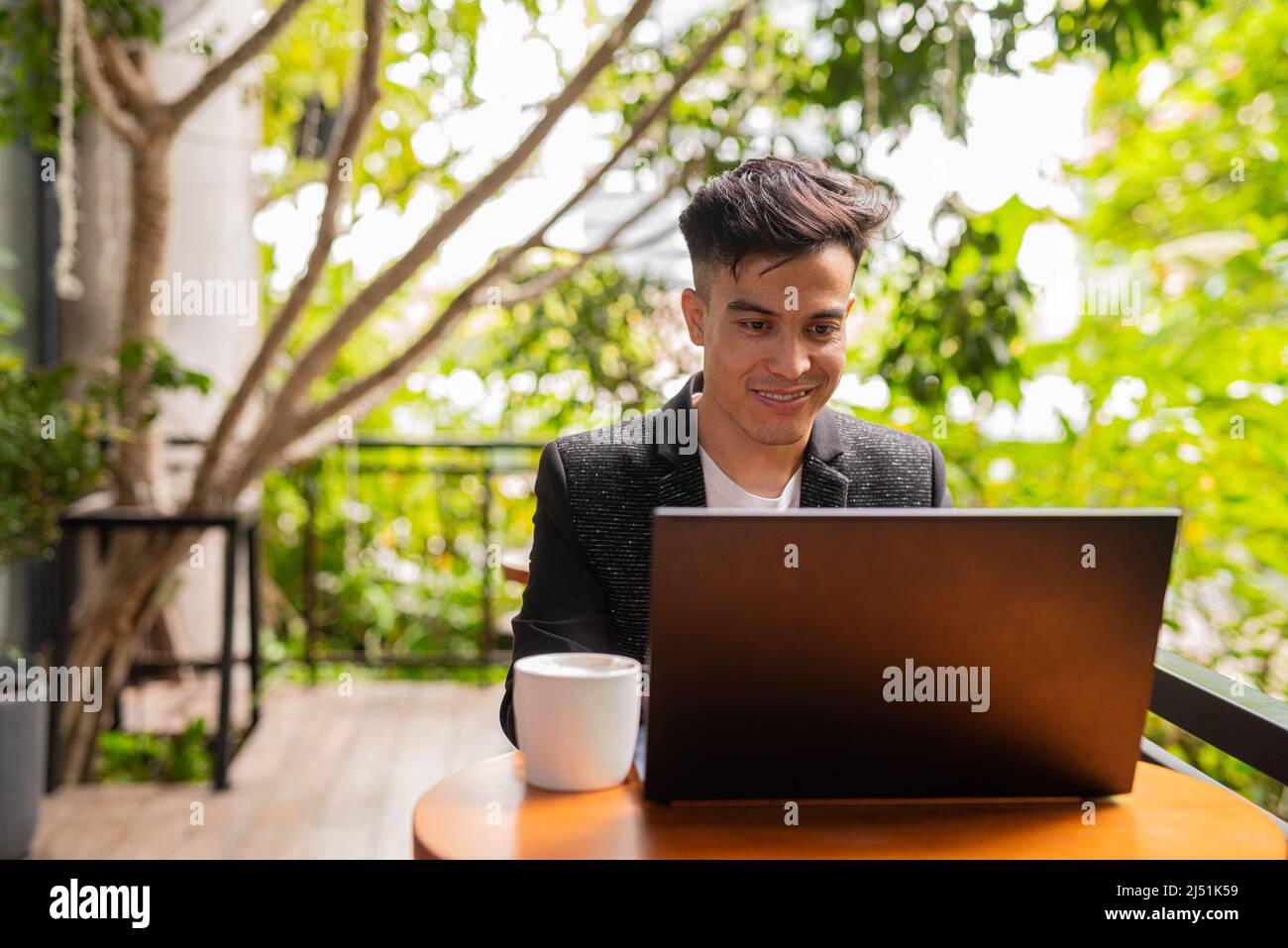 Jeune homme d'affaires utilisant un ordinateur portable dans un café Banque D'Images