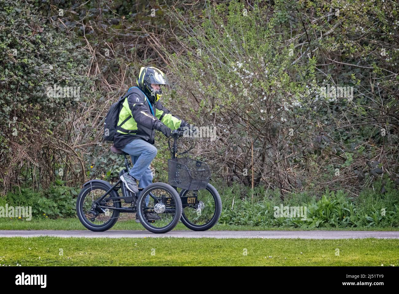 Cycliste mâle avec casque intégral, à vélo électrique à trois roues sur la piste de Warminster, Wiltshire, Royaume-Uni, le 19 avril 2022 Banque D'Images