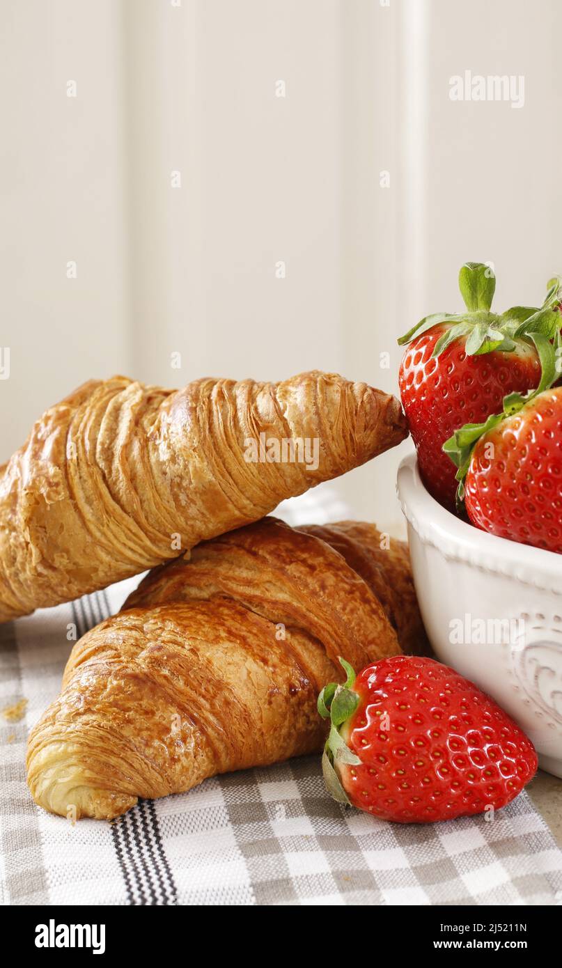Bol de fraises et deux croissants français. Heure du petit déjeuner Banque D'Images