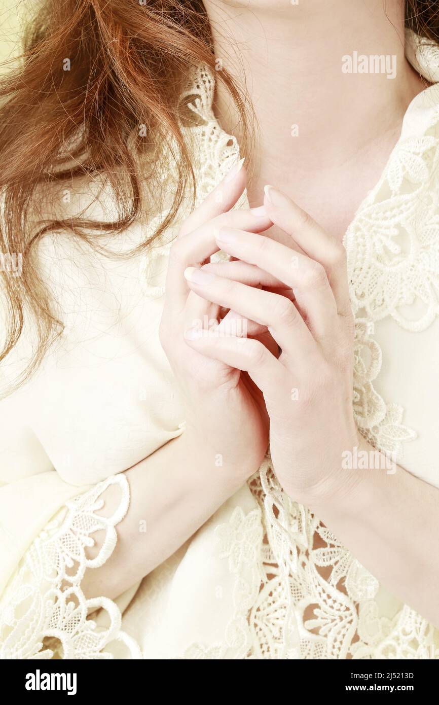 La jeune femme porte une luxueuse robe en dentelle. Détail de ses mains. Banque D'Images
