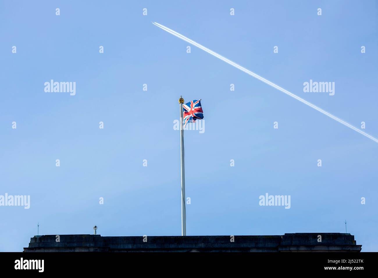 Un contrail est vu au-dessus d'un drapeau de l'Union volant sur le toit de Buckingham Palace dans le centre de Londres avant le jour de l'accession. Banque D'Images