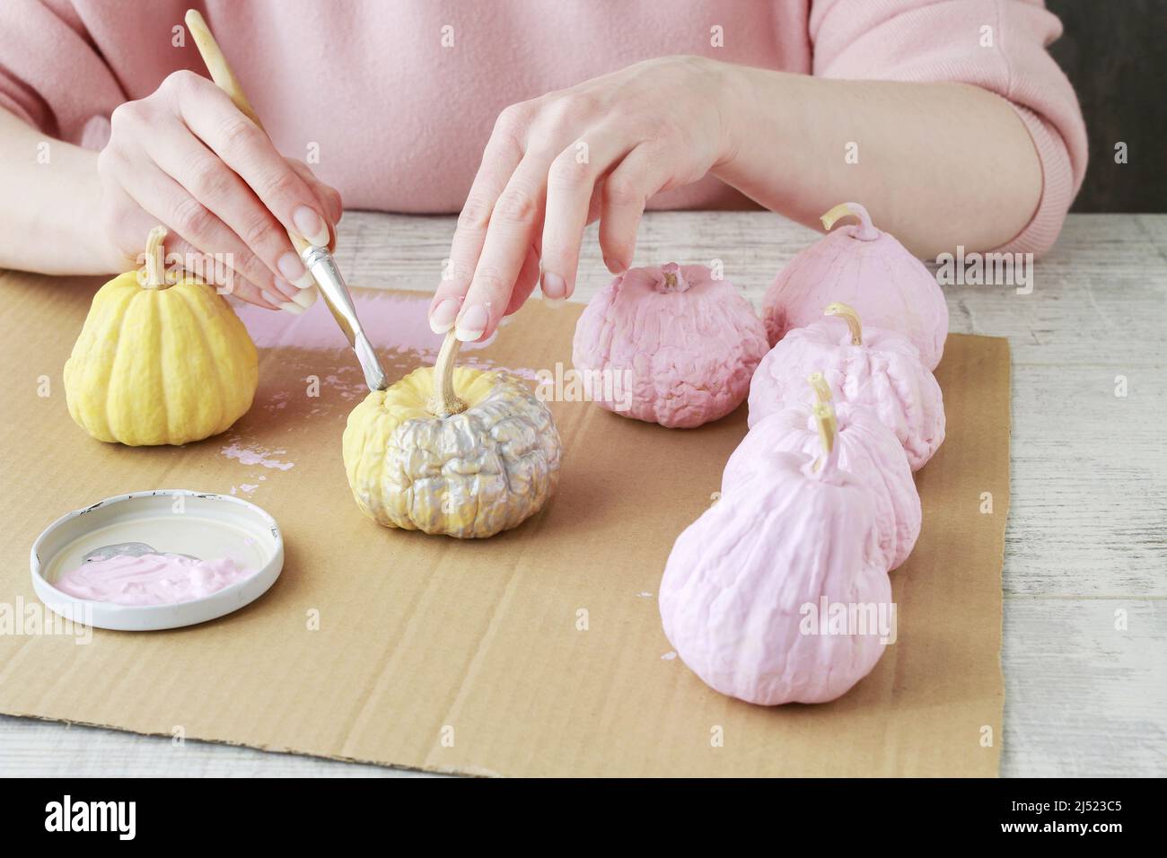 Femme peint des citrouilles miniatures avec de la peinture. Idées de décoration d'intérieur. Banque D'Images