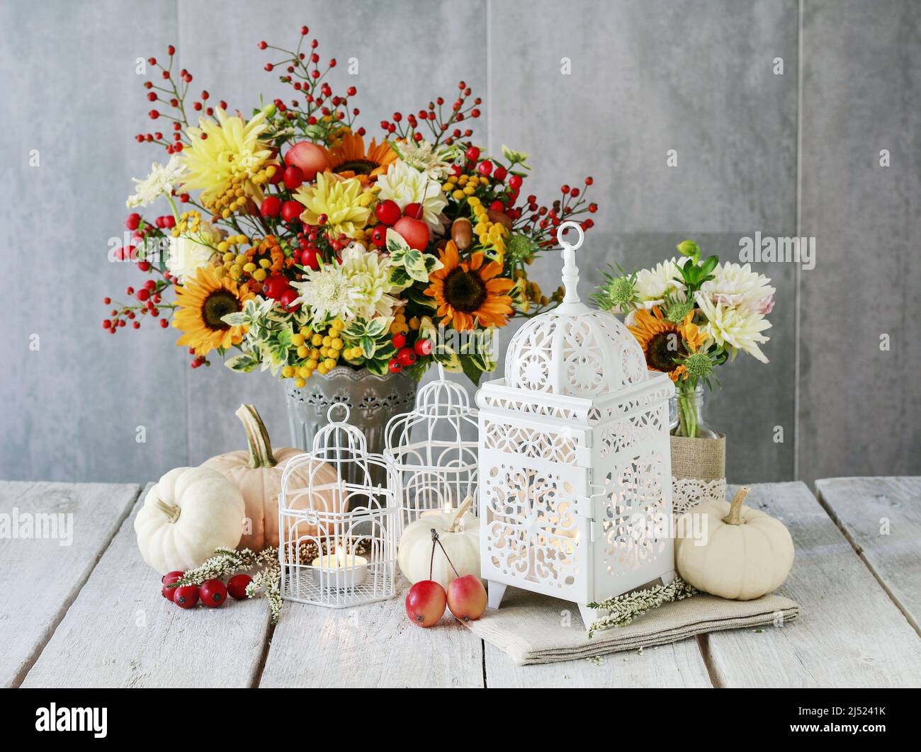 Belle lanterne blanche, fleurs et citrouilles sur la table. Décoration romantique d'automne. Banque D'Images