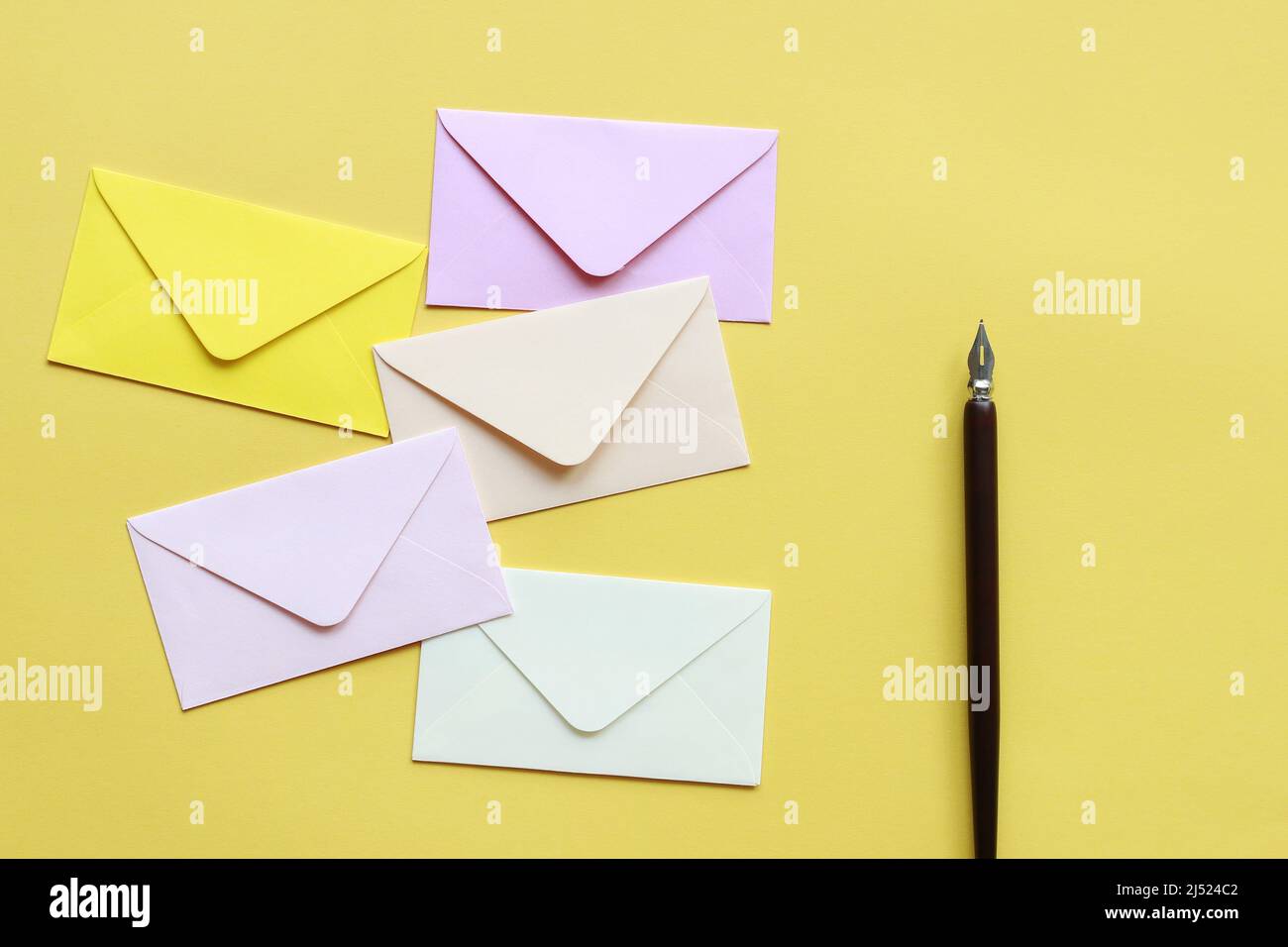 Enveloppes colorées sur fond jaune, espace de copie. Banque D'Images
