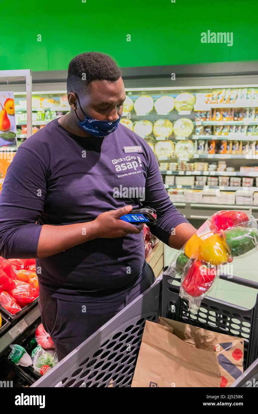 Cape Town, Afrique du Sud - 9 septembre 2021 : un membre du personnel cueille des produits à partir de l'étagère pour un service de livraison express à domicile Banque D'Images