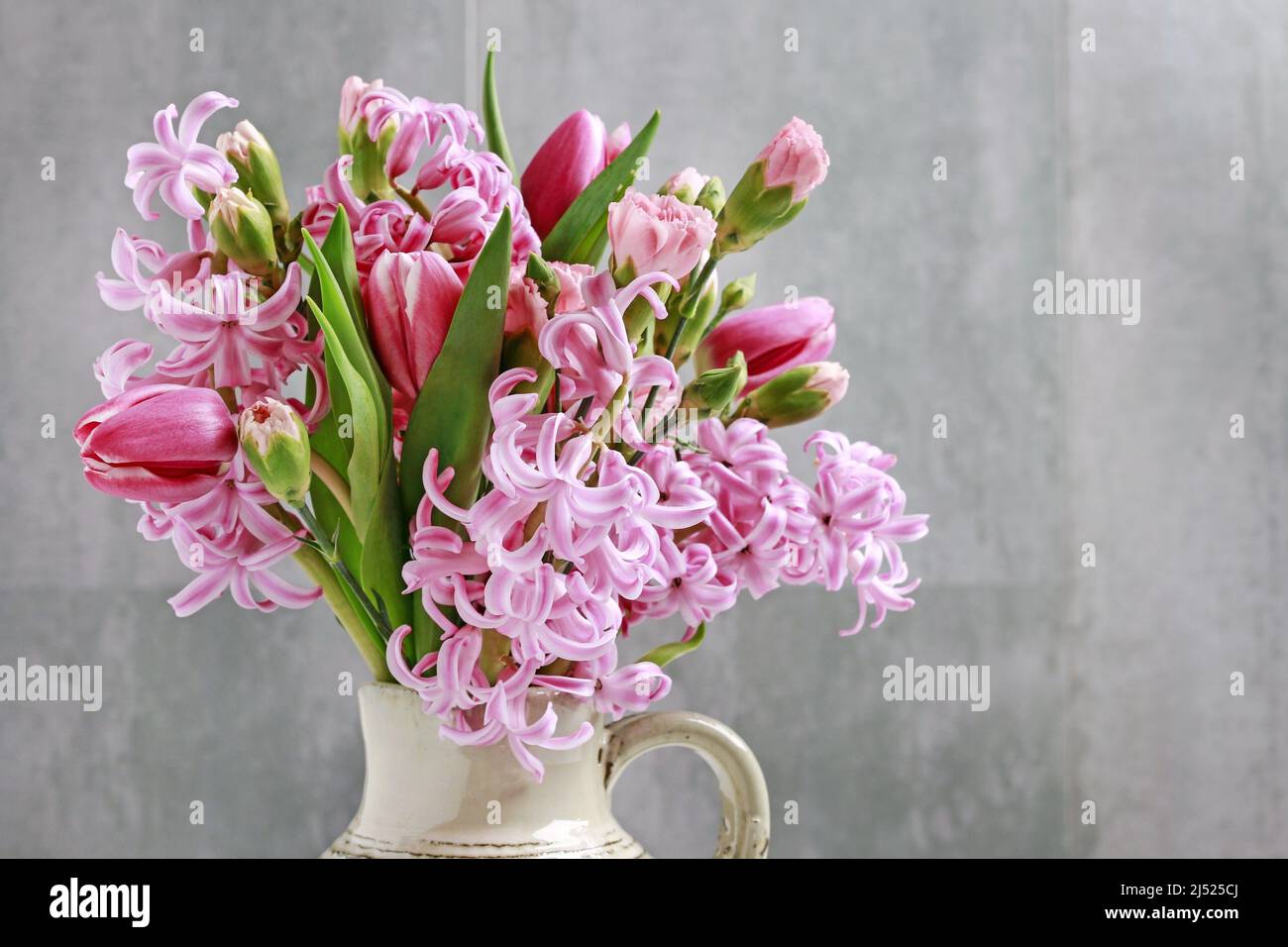 Fleuriste au travail: Femme montre comment faire le bouquet de printemps avec des fleurs de tulipe, de jacinthe et de carnation. Étape par étape, tutoriel. Banque D'Images