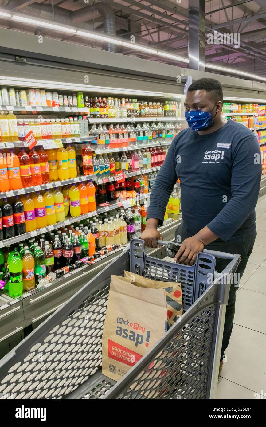 Cape Town, Afrique du Sud - 9 septembre 2021 : un membre du personnel cueille des produits à partir de l'étagère pour un service de livraison express à domicile Banque D'Images