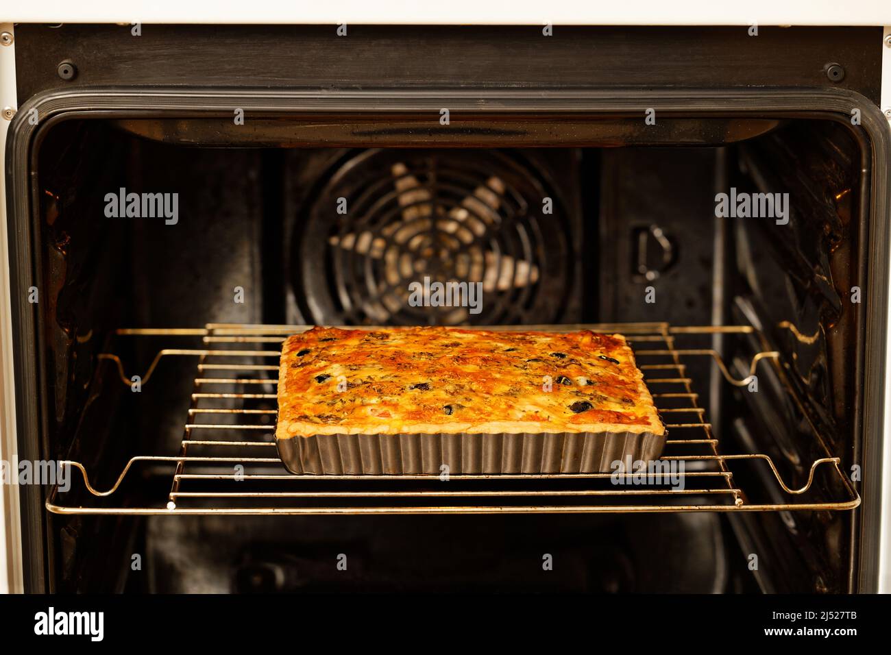 Quiche maison à la guesy avec tomates, champignons et olives cuites dans un four maison. Mise au point peu profonde. Banque D'Images Quiche maison à la guesy avec tomates, champignons et olives cuites dans un four maison. Mise au point peu profonde. Banque D'Images