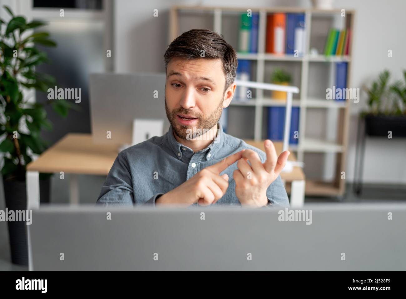 Concept de réunion virtuelle. Portrait d'un responsable d'entreprise mature qui parle à l'aide d'un ordinateur sur son lieu de travail au bureau Banque D'Images