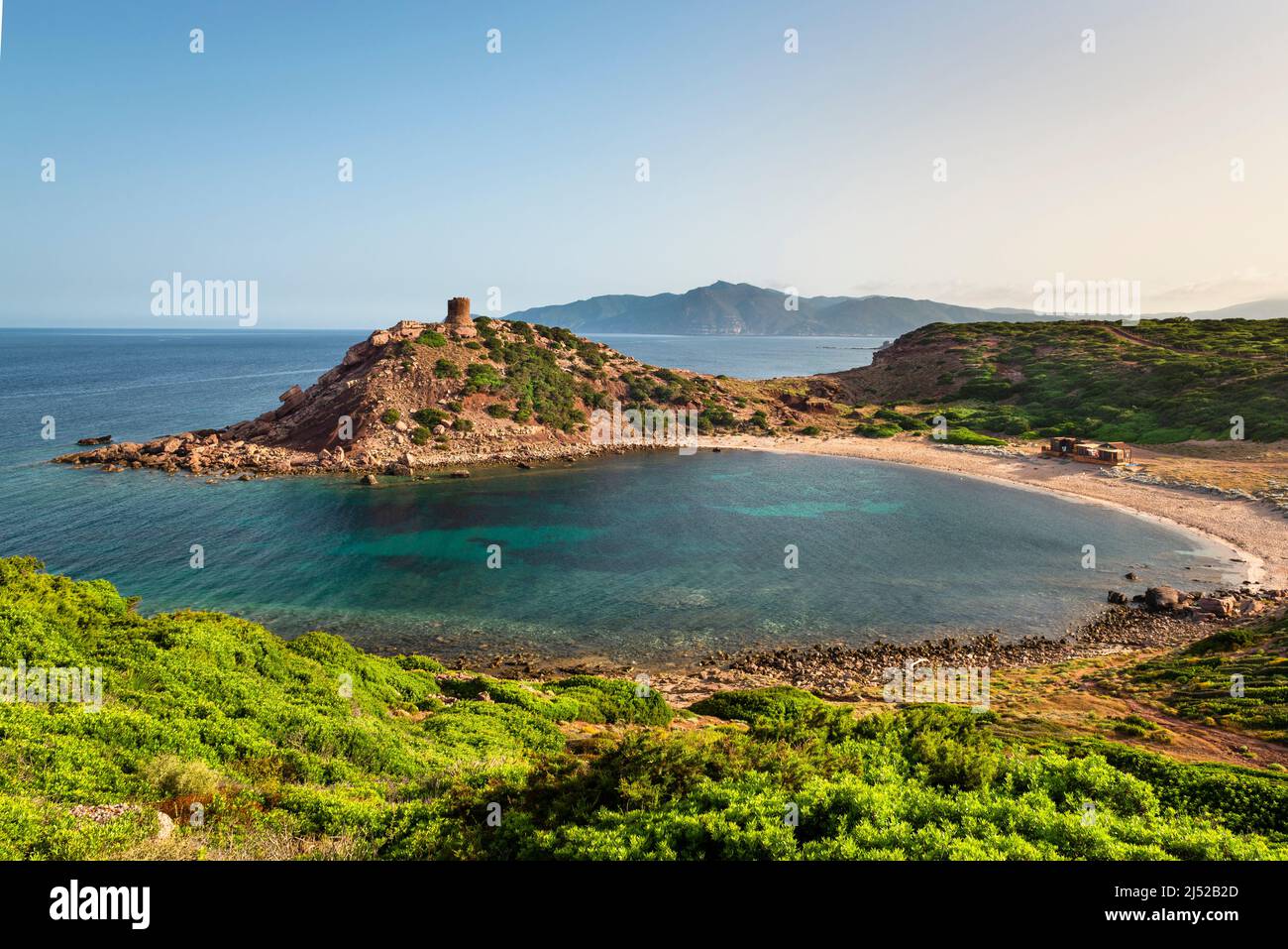 Paysage méditerranéen côtier - la tour de guet et la plage de la baie Torre del Porticciolo et le Cap Argentiera au soleil du matin, la Sardaigne Banque D'Images