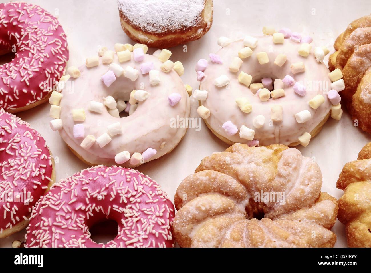 Divers types de beignets sur fond rose. Dessert de fête Banque D'Images